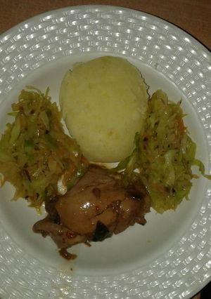 A picture of Mashed potatoes with fried cabbage & stewed chiken.