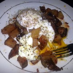 A picture of Breakfast potatoes with poached eggs.