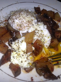 A picture of Breakfast potatoes with poached eggs.