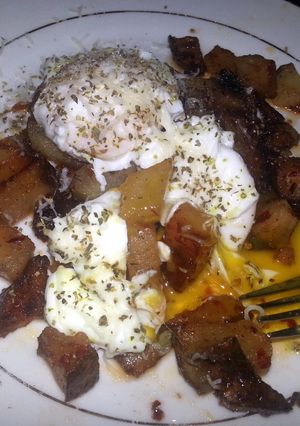 A picture of Breakfast potatoes with poached eggs.