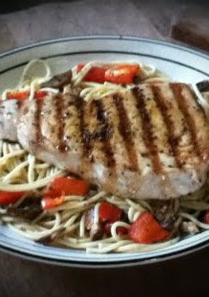 A picture of Blue Marlin over Mushroom and Pepper Pasta.