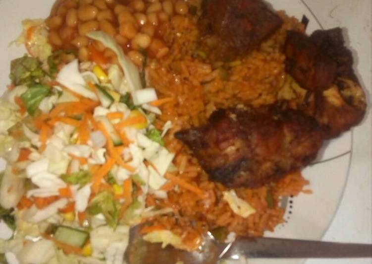 Jollof rice with salad and chicken,