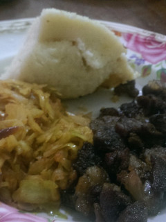 A picture of Fried lamb,steamed cabbage served with ugali.