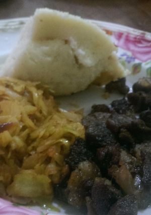 A picture of Fried lamb,steamed cabbage served with ugali.
