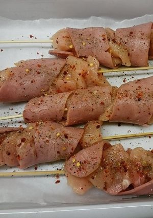 A picture of chicken skewers with turkey bacon.