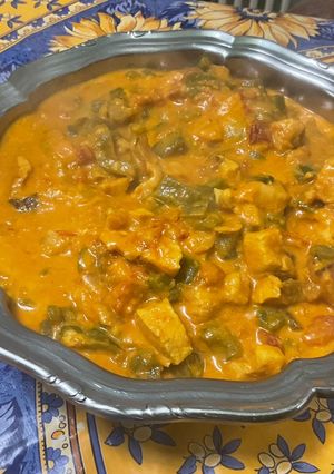 A picture of Chicken and Bacon with Peppers, Tomatoes, Spices, and Coconut Milk.