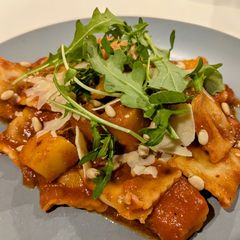 A picture of Ravioli and pumpkin in tomato sauce.