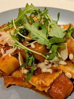 A picture of Ravioli and pumpkin in tomato sauce.