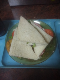 Una foto de Sándwich de pechuga empanada con lechuga, tomate y mayonesa