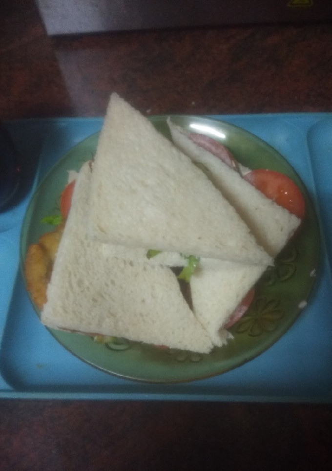 Una foto de Sándwich de pechuga empanada con lechuga, tomate y mayonesa