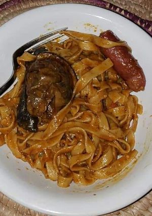 A picture of Pasta with sausage and fried fish.