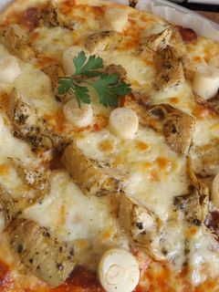 Una foto de Pizza casera con quesos, alcachofas, palmitos y salchichón ibérico