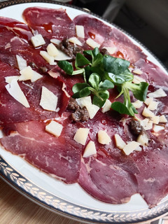 Una foto de Carpaccio de cecina con salsa de trufas y queso viejo tostado