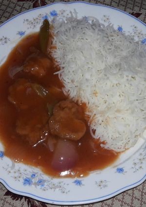A picture of Chicken manchurian with plain rice.