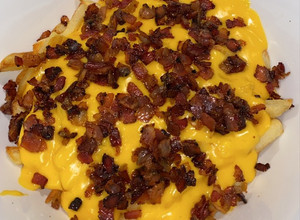 Una foto de Papas con Queso Cheddar y Panceta