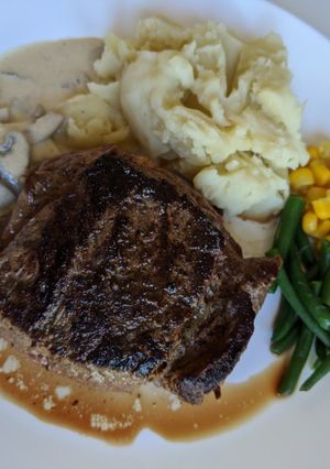 A picture of Homemade steak and mashed potato with garlic and pepper sauce.