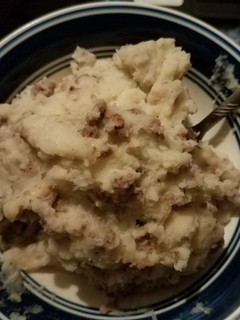 A picture of Mashed potatoes and hamburger meat with gravy.