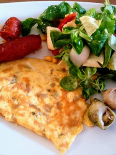Una foto de Tortilla de finas hierbas, ensalada, bulots y chorizo asado