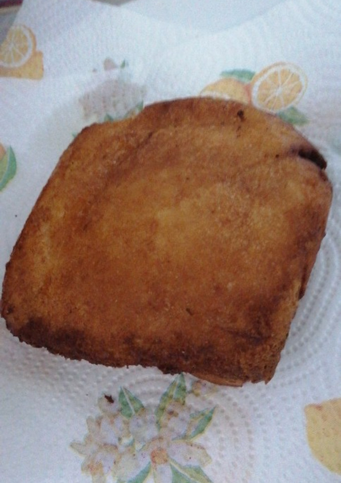 Una foto de Torrijas rellenas de crema y rebozadas de miel, canela y azúcar