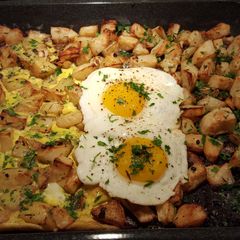 A picture of Roasted herb and garlic potatoes with eggs cooked two ways.