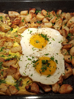 A picture of Roasted herb and garlic potatoes with eggs cooked two ways.