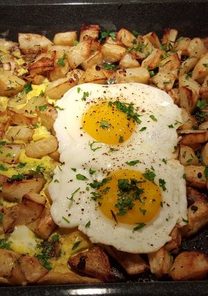 A picture of Roasted herb and garlic potatoes with eggs cooked two ways.