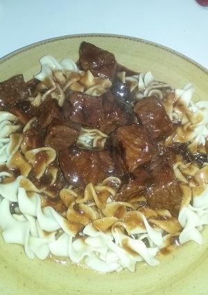 A picture of Beef tips with gravy over egg noodles.