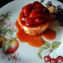 A picture of Vanilla Cheesecakes with Roasted Strawberry Sauce.