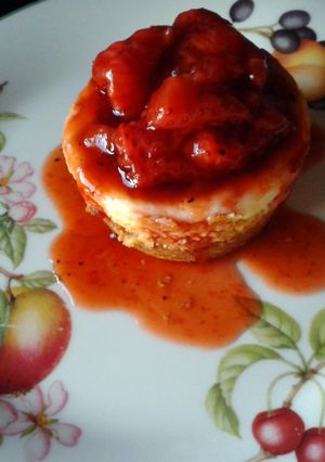 A picture of Vanilla Cheesecakes with Roasted Strawberry Sauce.