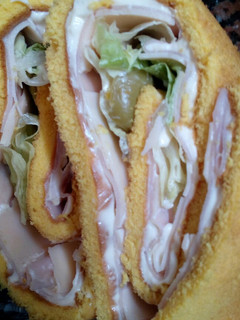 Una foto de Pionono Relleno de Jamón, queso, lechuga y aceitunas