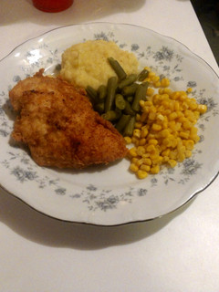 A picture of fried chicken with mashed potatoes.