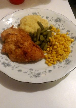 A picture of fried chicken with mashed potatoes.