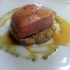 A picture of Steamed salmon, orange juice reduction, simple herbs sauce..