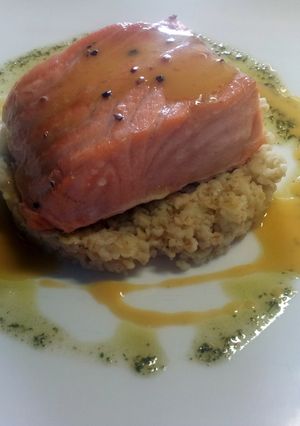 A picture of Steamed salmon, orange juice reduction, simple herbs sauce..