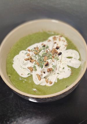 A picture of Purslane Soup with Goat Cheese Whipped Cream and Hazelnut Oil.