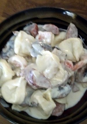 A picture of Fettucine alfredo w/shrimp, andouille sausage, and mushrooms.