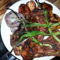 A picture of Grilled pork steaks with grilled veggies.