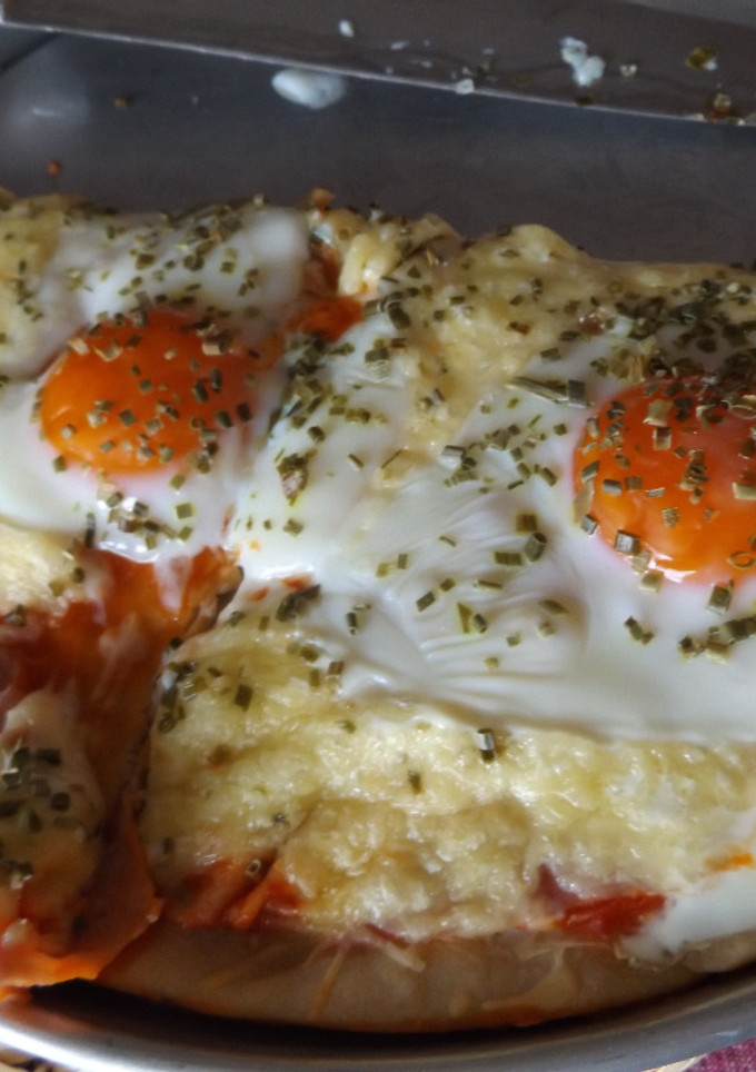 Una foto de Pizza casera de jamón y queso con huevos