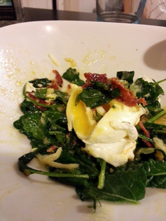A picture of Sauted Kale Topped with Poached Egg + Crispy Chorizo.