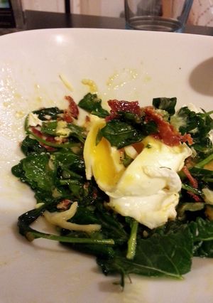 A picture of Sauted Kale Topped with Poached Egg + Crispy Chorizo.