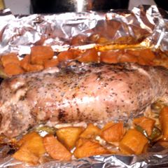 A picture of marinated pork tenderloin pepercorn and garlic with sliced sweet potatos.