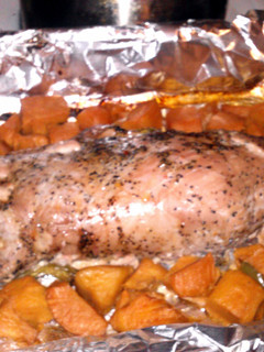 A picture of marinated pork tenderloin pepercorn and garlic with sliced sweet potatos.