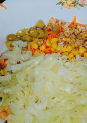 Una foto de Ensalada de repollo, zanahoria, aceitunas, nueces y choclo