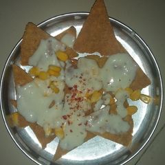 A picture of Nachos with cheese sauce.