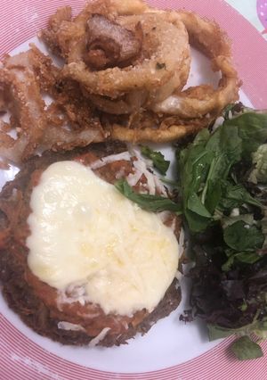 Una foto de Medallón de lenteja con aros de cebolla y ensalada