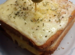 Una foto de Sándwich caliente con muzzarella y relleno con tomate, jamón y queso🥪