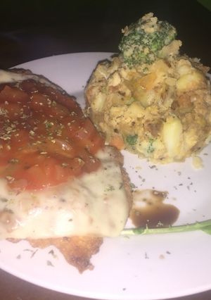 Una foto de Milanesa a la napolitana con papas salteadas