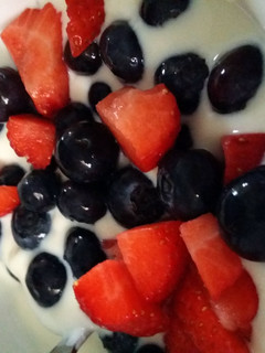 A picture of Blueberries and strawberries in yoghurt.
