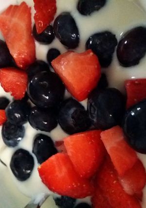 A picture of Blueberries and strawberries in yoghurt.