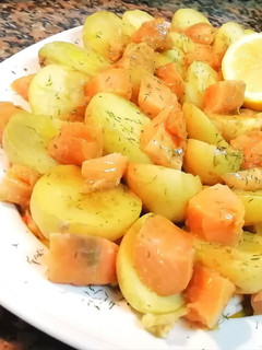 Una foto de Sashimi de salmón fresco, con patatas cocidas y langostinos